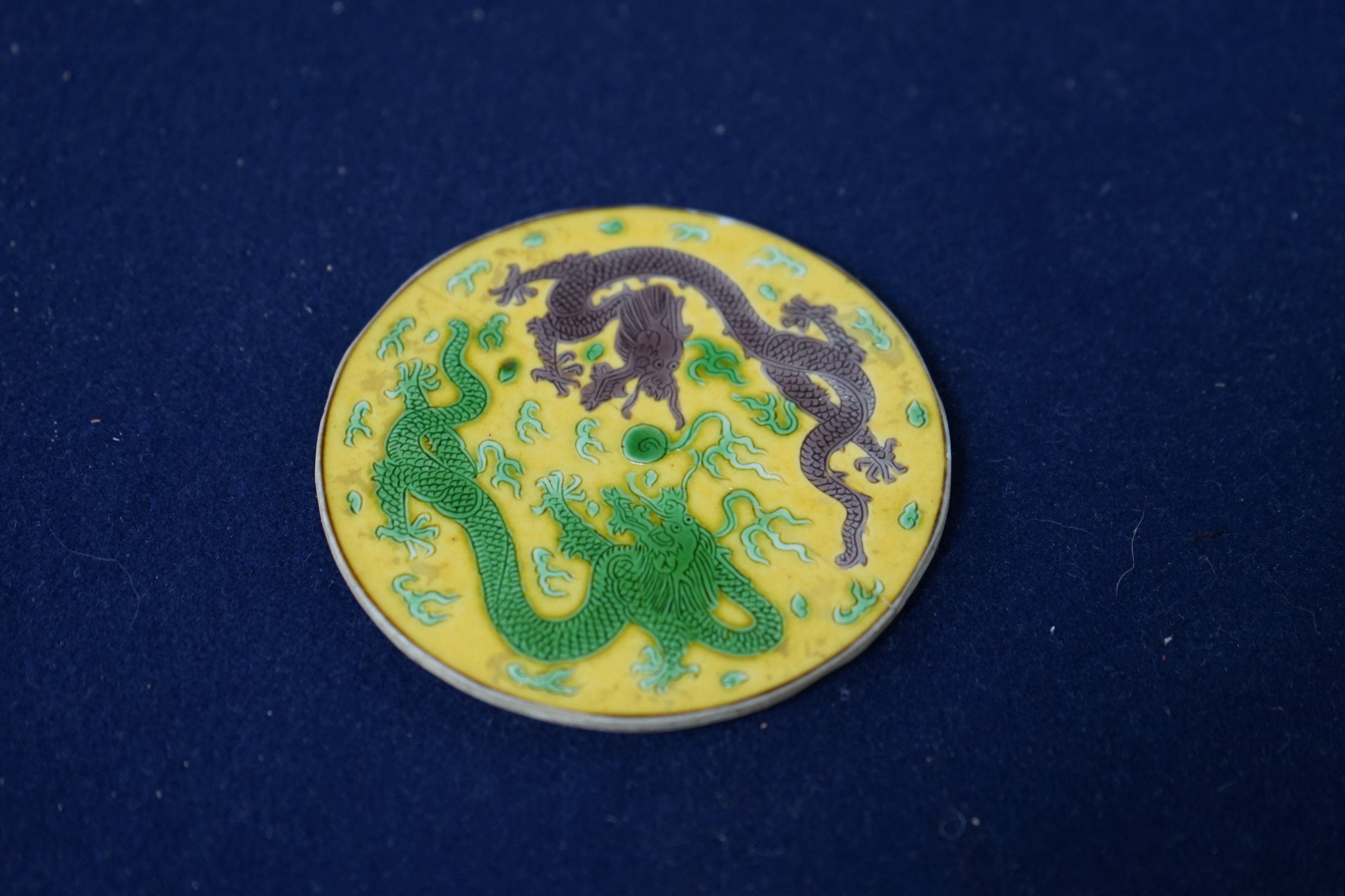 A Chinese sancai porcelain ‘dragon’ roundel, cut from the centre of a dish, Daoguang mark and period, 9cm diameter